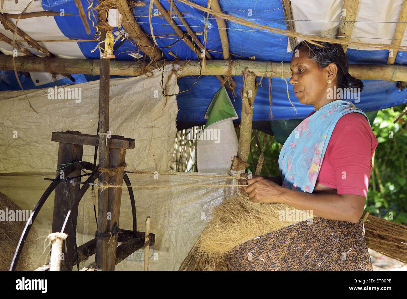 Keralite woman making coir rope in cottage ; traditional method