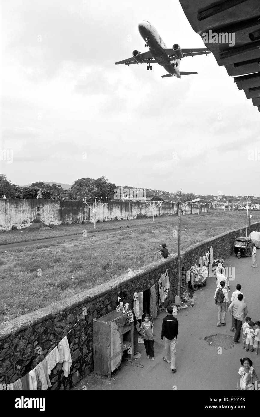 Aeroplane flying over kamani indira nagar and kaju pada slum ; Bombay Mumbai ; Maharashtra ; India Stock Photo