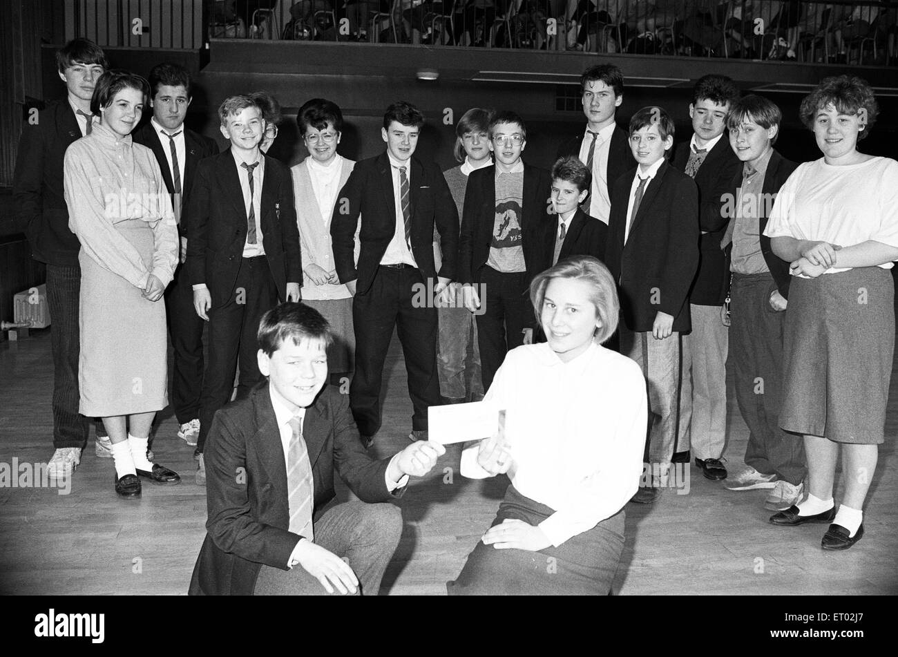 Colne Valley High School pupils Steven Clegg and Lemini Whitley with a £200 cheque which will go towards the cost of a new piano at Heathland's old people's home. The money was raised by fourth form pupils through a variety of events including sponsored hockey, basketball, a cross country run and a charity disco. 13th January 1988. Stock Photo