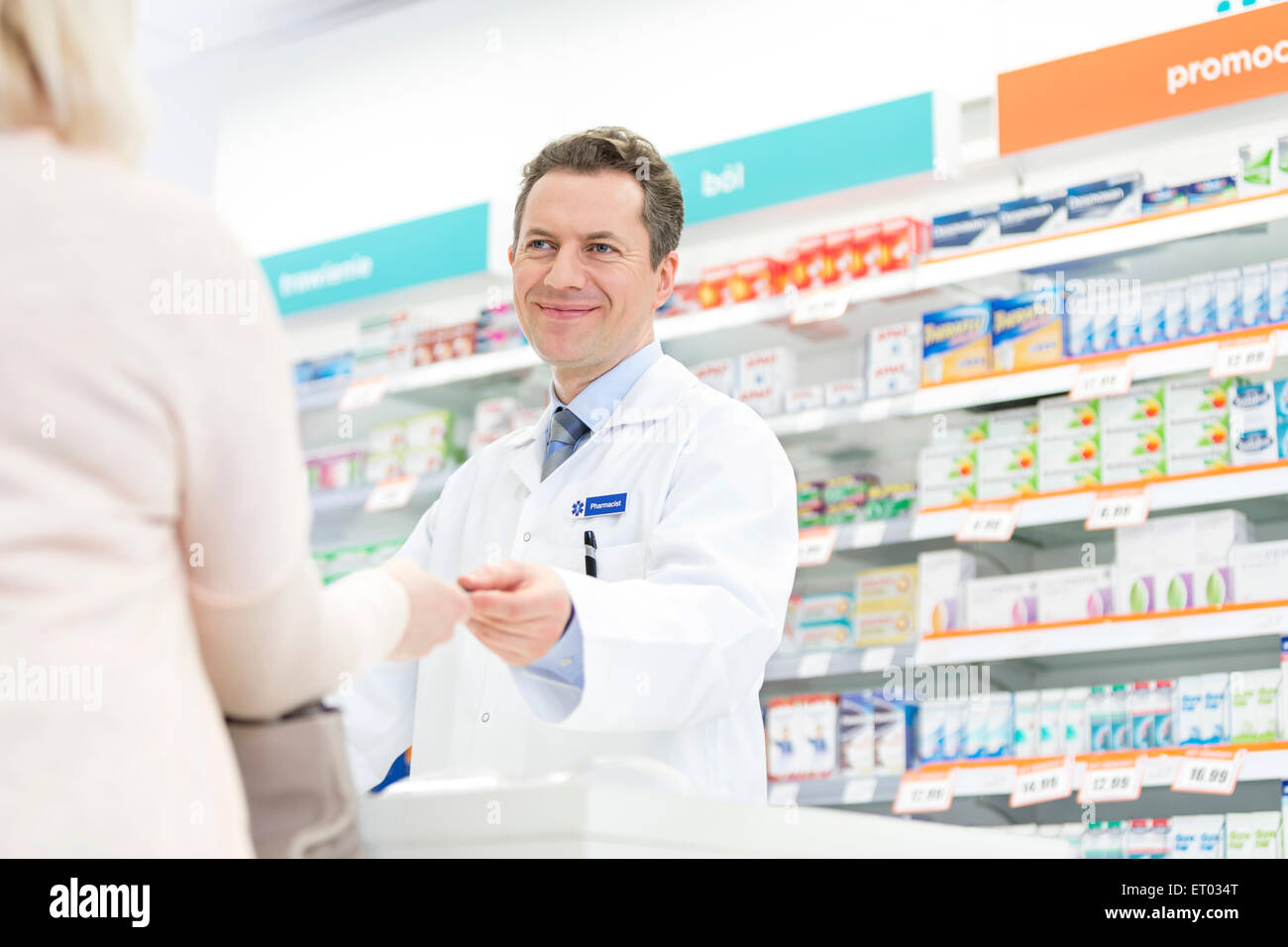 Smiling pharmacist assisting customer in pharmacy Stock Photo