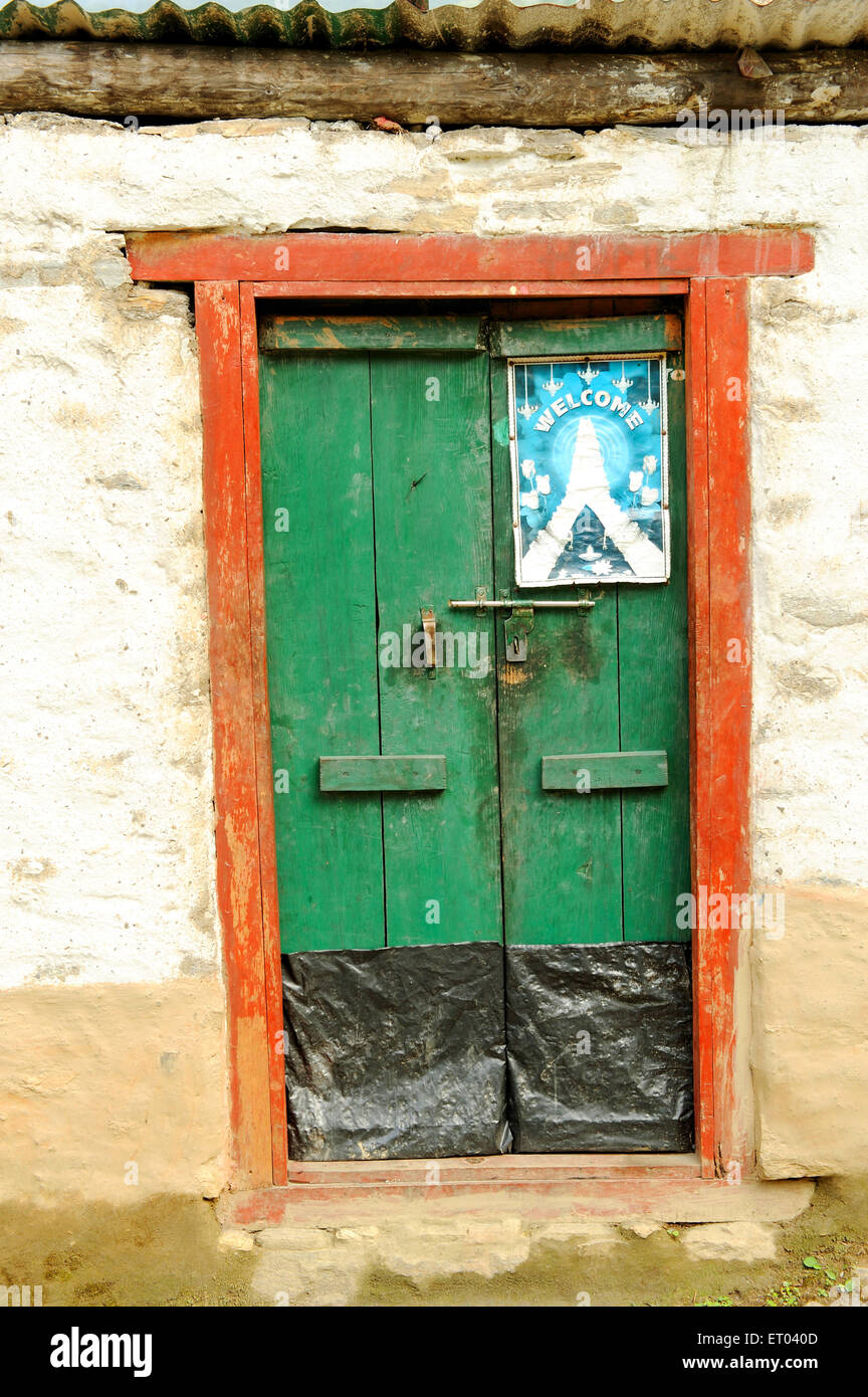 Welcome poster on green door , Tatopani , Sindhupalchok , Bagmati  , Nepal , Federal Democratic Republic of Nepal , South Asia , Asia Stock Photo