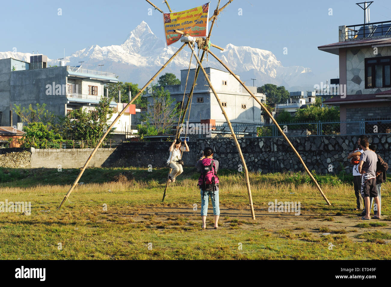 Tourist swinging , Machhapuchchhre , Fishtail mountain , Pokhara , Nepal , Federal Democratic Republic of Nepal , South Asia , Asia Stock Photo