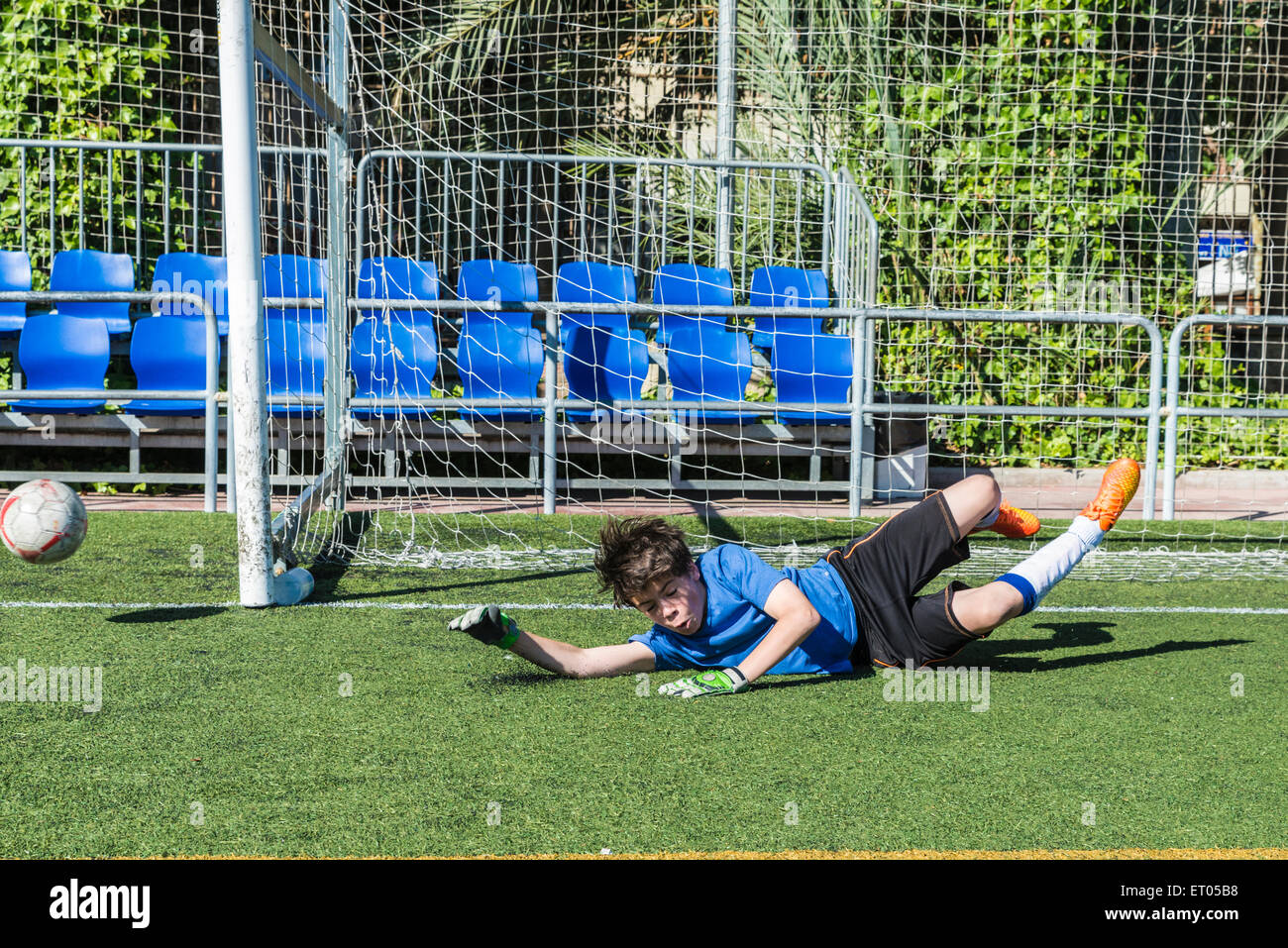 Young football goalkeeper stretching to stop a ball Stock Photo Alamy