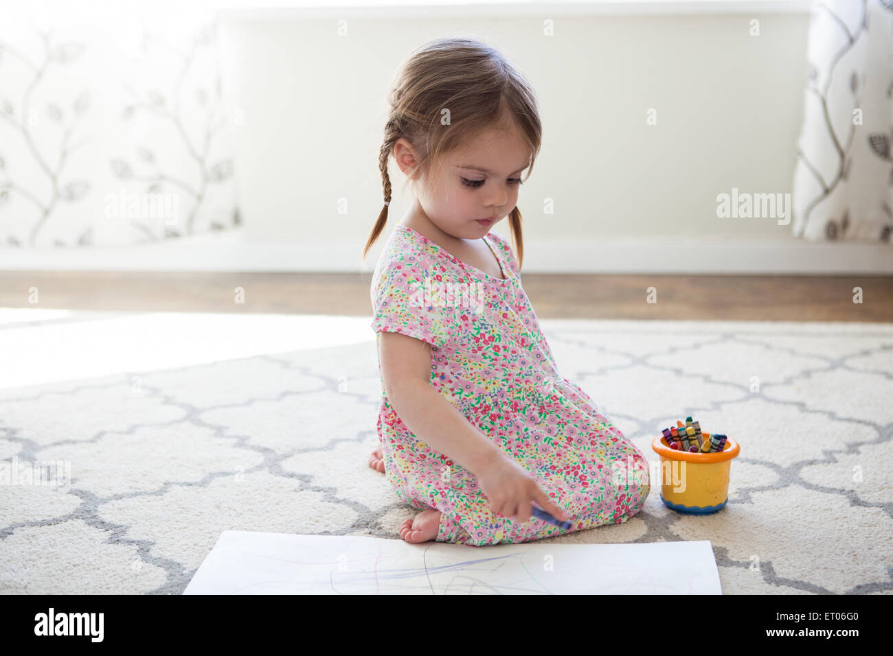 Girl in dress drawing with crayons Stock Photo