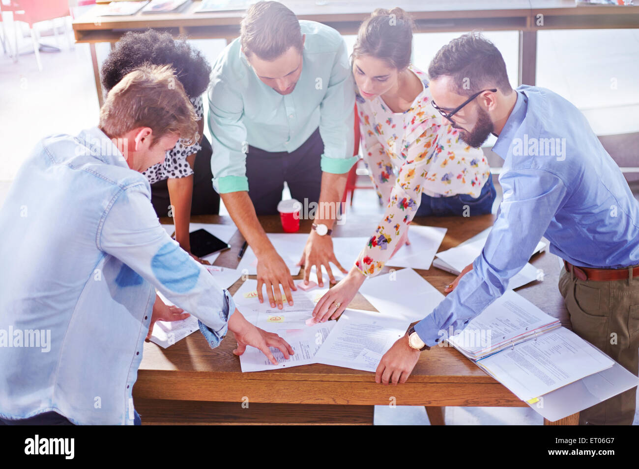 Business people reviewing paperwork and brainstorming in meeting Stock Photo