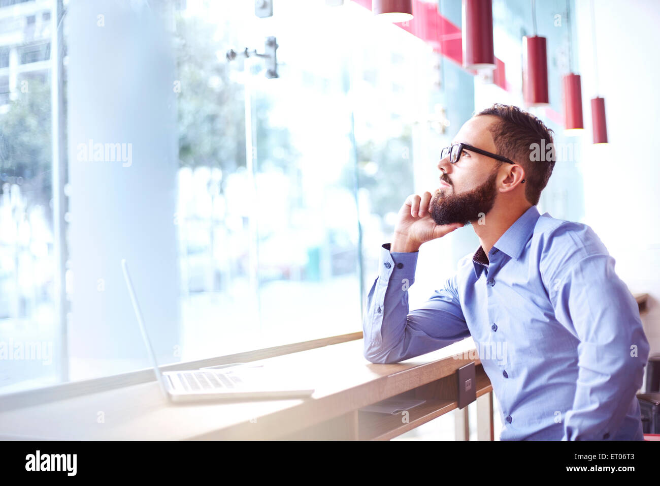 Pensive businessman at laptop in cafe Stock Photo