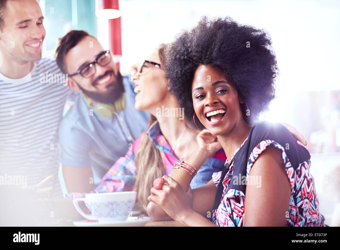 Portrait of laughing woman hanging out with friends in cafe Stock Photo
