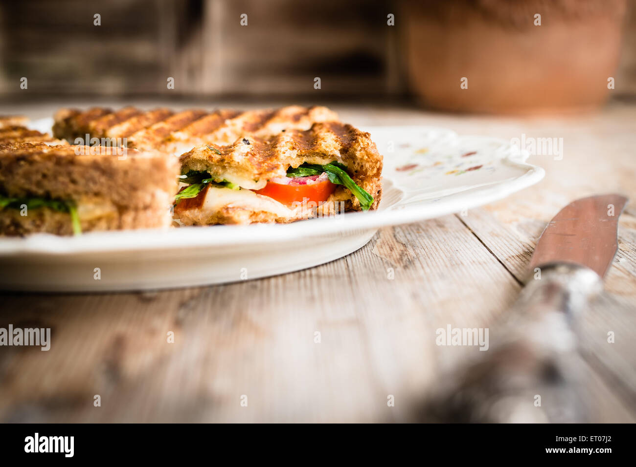 Vegetarian panini with tomatoes and mozzarella on rustic wooden table. Selective focus. Stock Photo