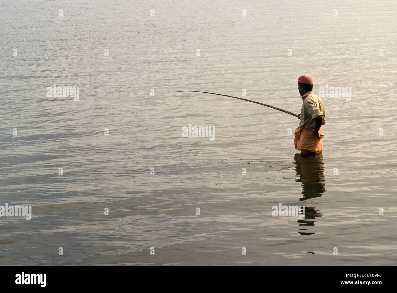 man fishing with fishing rod in backwaters , Alapuzha , Alappuzha ,  Alleppey , Kerala , India , asia Stock Photo