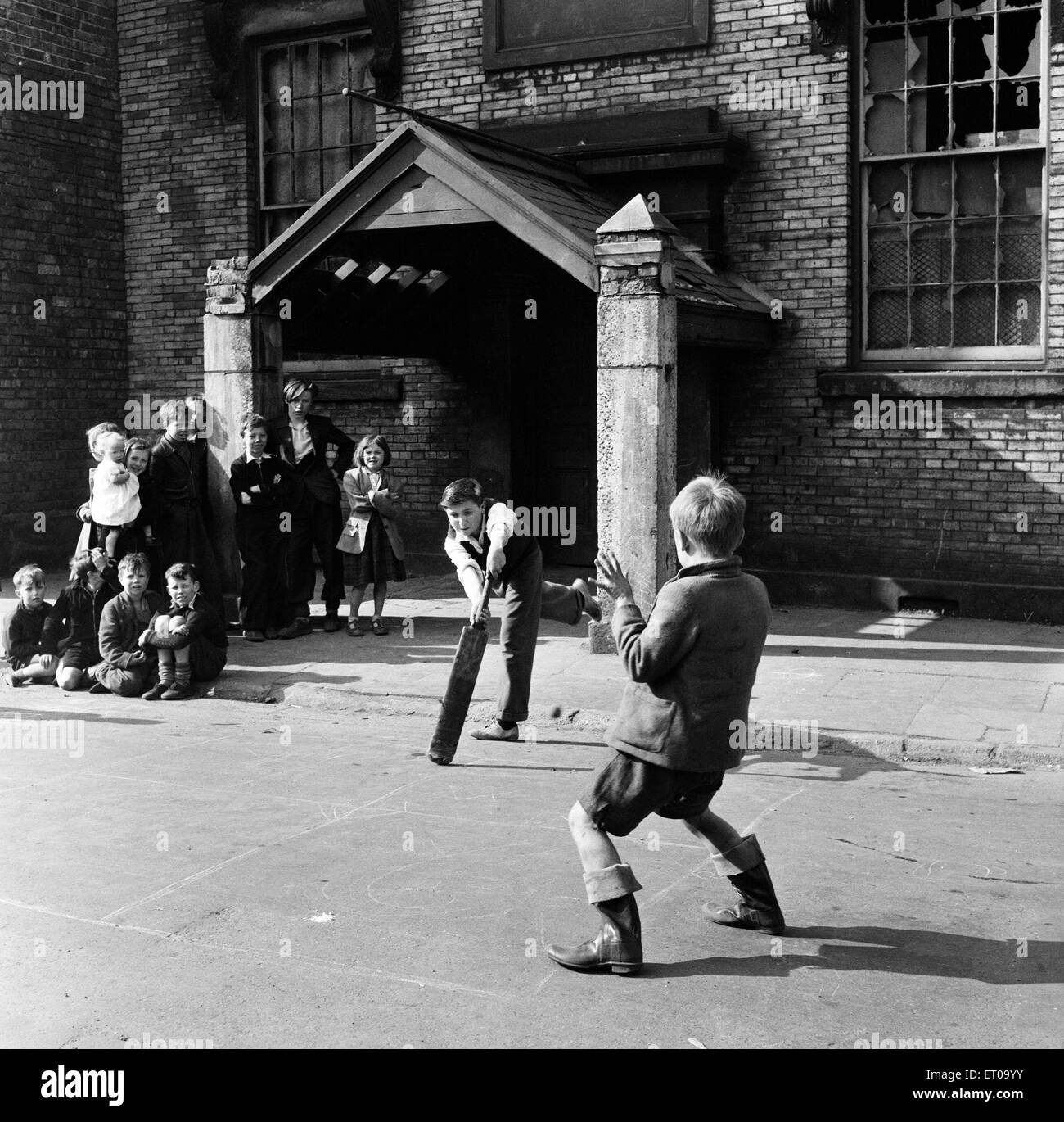 Children playing cricket in a back street in Sunderland, Tyne and Wear (formally County Durham). 28th April 1954. Stock Photo