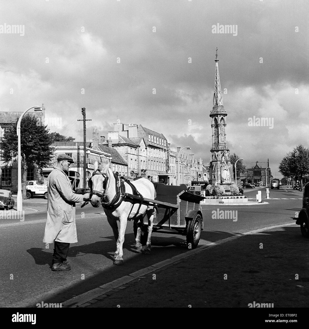 A man with a horse and cart in Banbury, with Banbury Cross in the background, Oxfordshire. 11th October 1952. Stock Photo