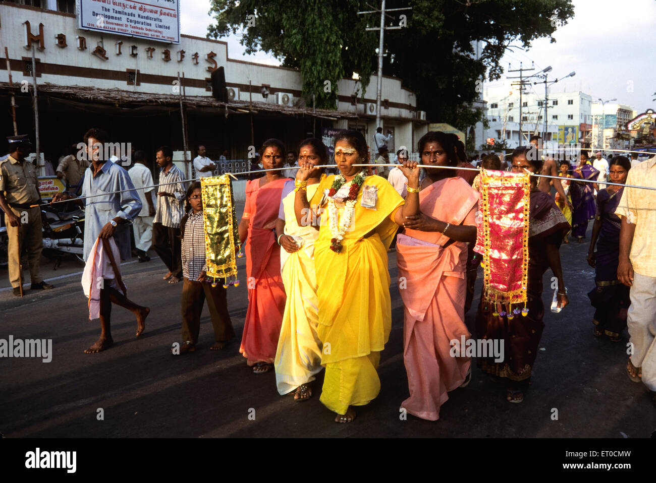 Woman piercing iron rod through cheeks discharging vow in Mariamman festival ; Tamil Nadu ; India NO MR Stock Photo