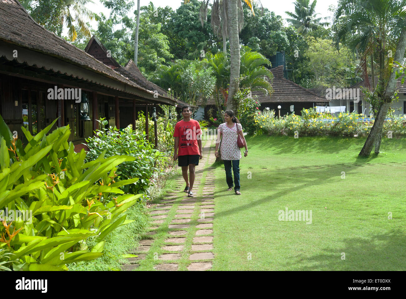 Couple walking in garden at heritage lake resort ; Kuttanad ; Alleppey Alappuzha ; Kerala ; India MR#777K;777L Stock Photo