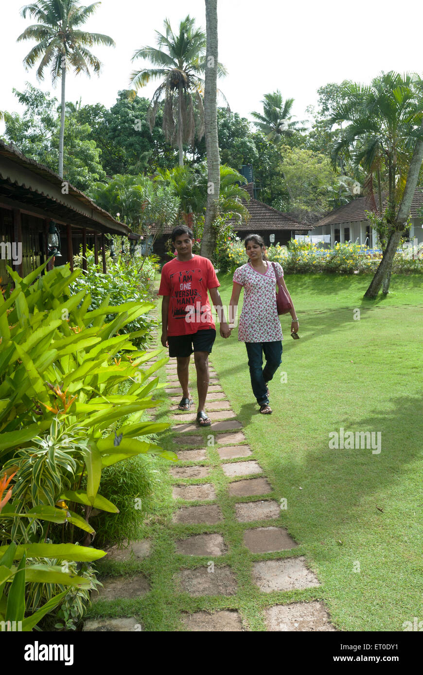 Couple walking in garden at heritage lake resort ; Kuttanad ; Alleppey Alappuzha ; Kerala ; India MR#777K;777L Stock Photo