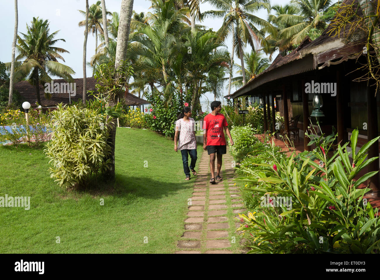 Couple walking in garden at heritage lake resort ; Kuttanad ; Alleppey Alappuzha ; Kerala ; India MR#777K;777L Stock Photo