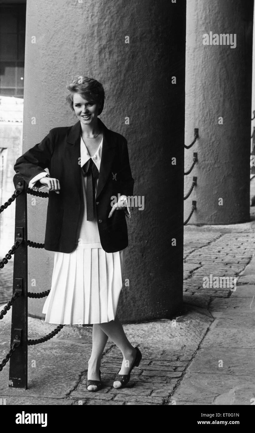 1980s Women's Fashion: Our model seen here at the Albert Dock wears a navy blazer over a white low pleated dress and a navy and white spotted bow. 15th February 1985 Stock Photo