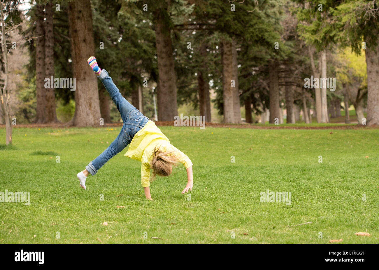 Young girl practicing summer salts at a park on a Spring day Stock ...