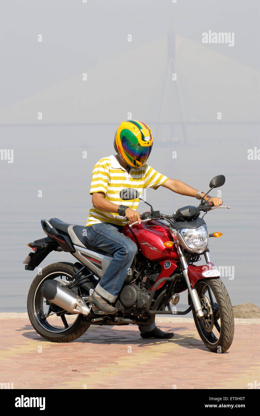 Young boy in helmet riding red coloured yamaha fz motorcycle 150cc sport bike ; Bombay Mumbai ; Maharashtra ; India MR#721 Stock Photo