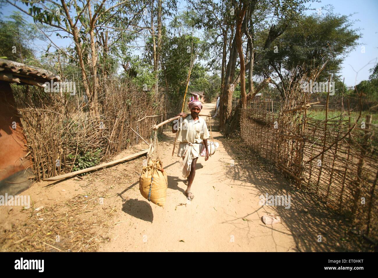 Indian rural man carrying grain balance scale village road, Ranchi, Jharkhand, India, Indian life Stock Photo