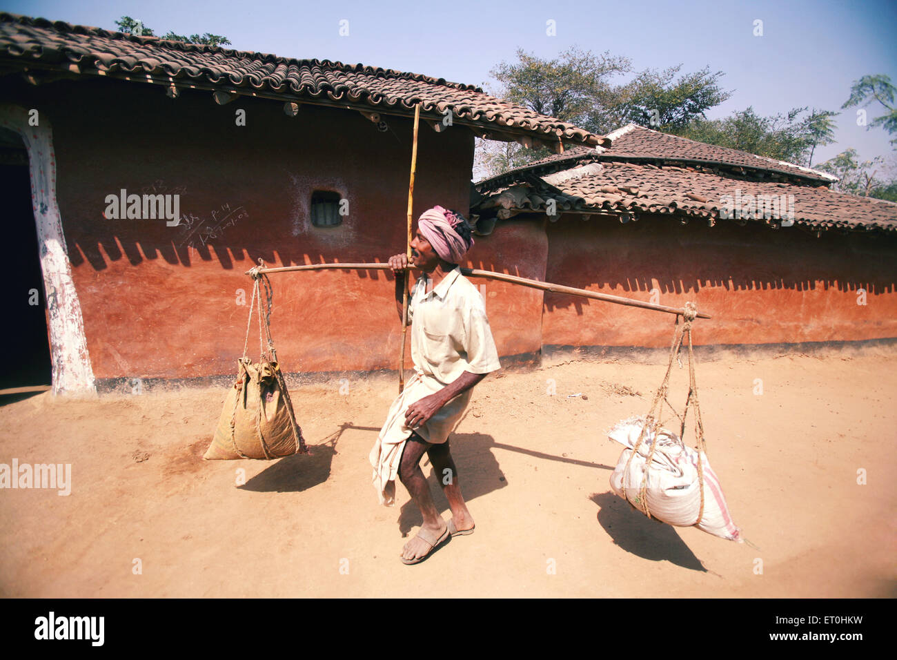 Traditional merchant sells grain home to home in exchange of old things in village in Jharkhand ; India NO MR Stock Photo