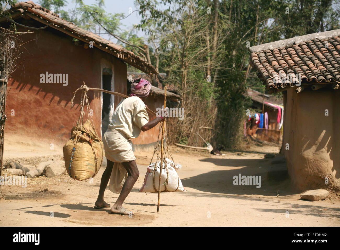 Indian rural man carrying grain balance scale village road, Ranchi, Jharkhand, India, Indian life Stock Photo