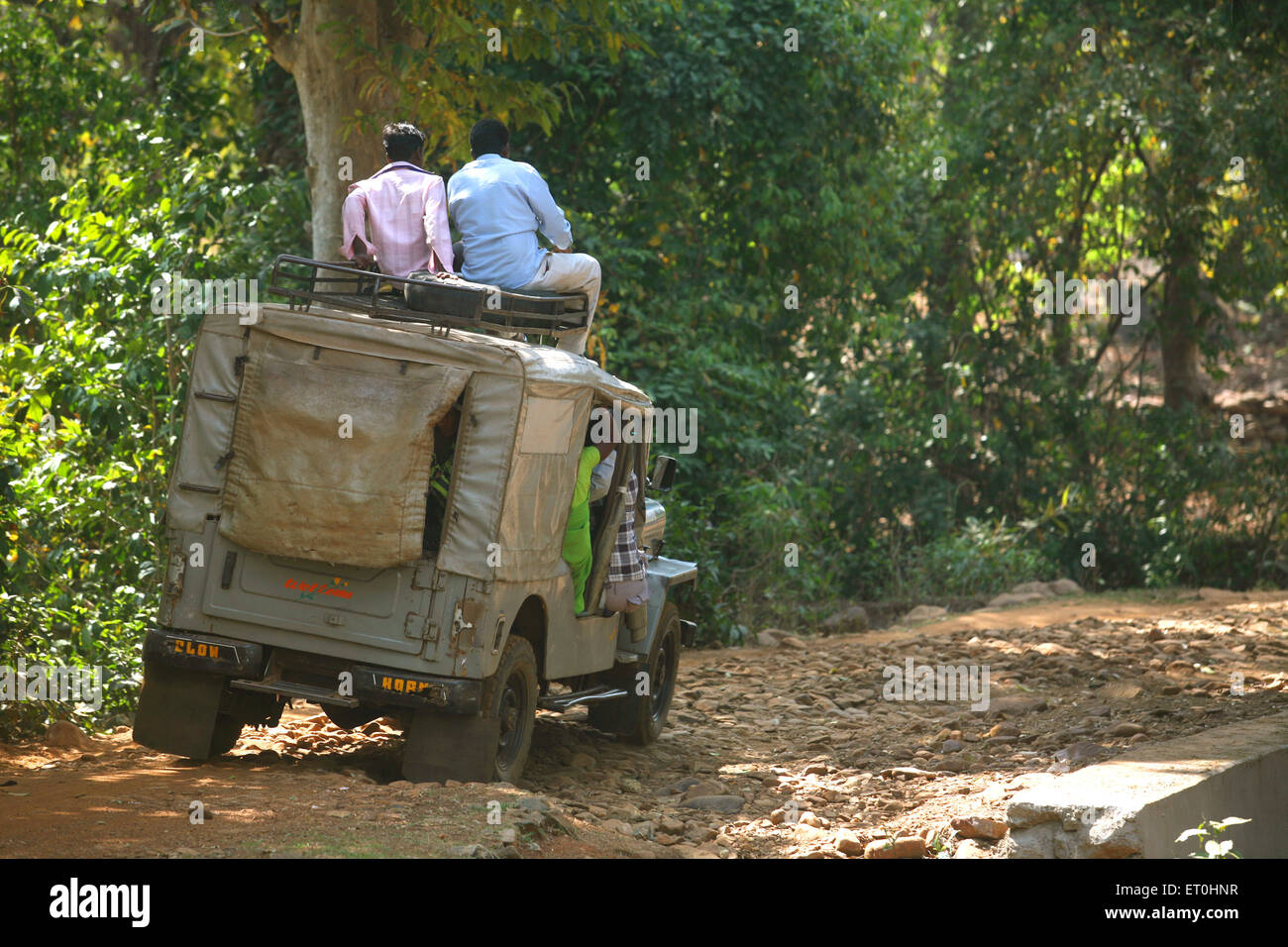 Passengers sitting on top of jeep used local transport system in Jharkhand ; India Stock Photo
