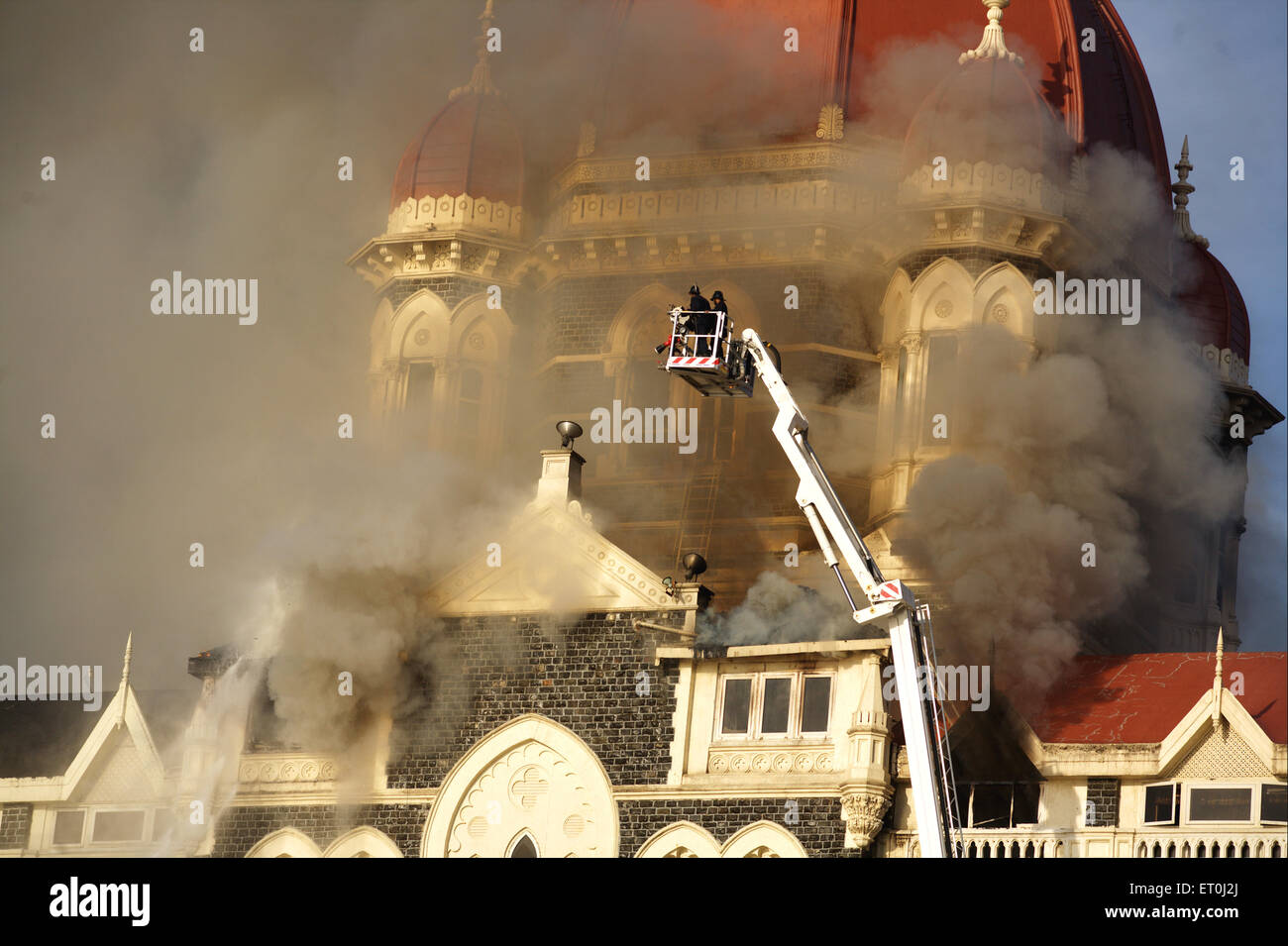 Smoke emits from Taj Mahal Hotel and fire brigade officers putting off fire during terrorist attack by Deccan Mujahideen Stock Photo