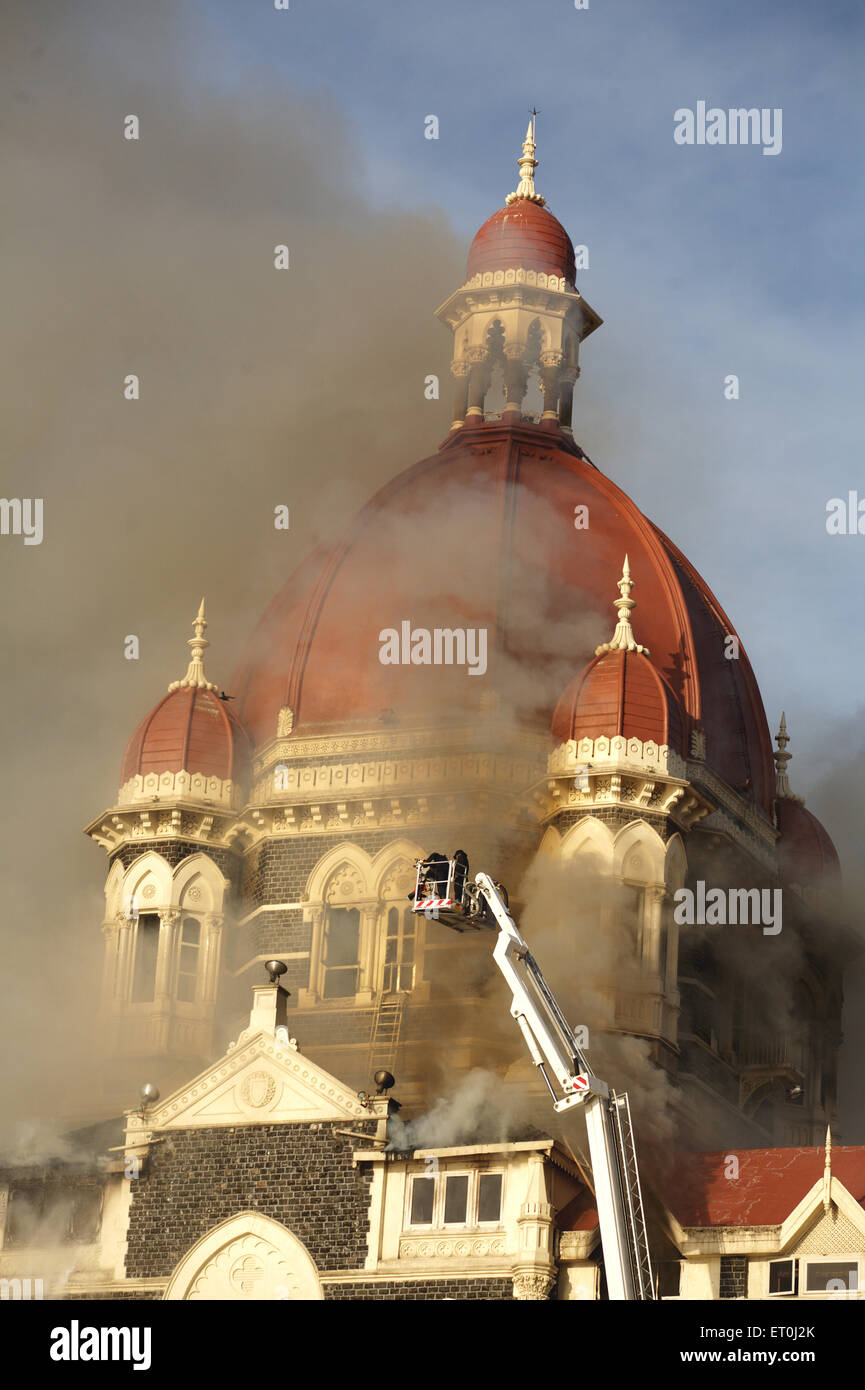 Smoke emits from Taj Mahal Hotel and fire brigade officers putting off fire during terrorist attack Deccan Mujahideen ; Bombay Stock Photo