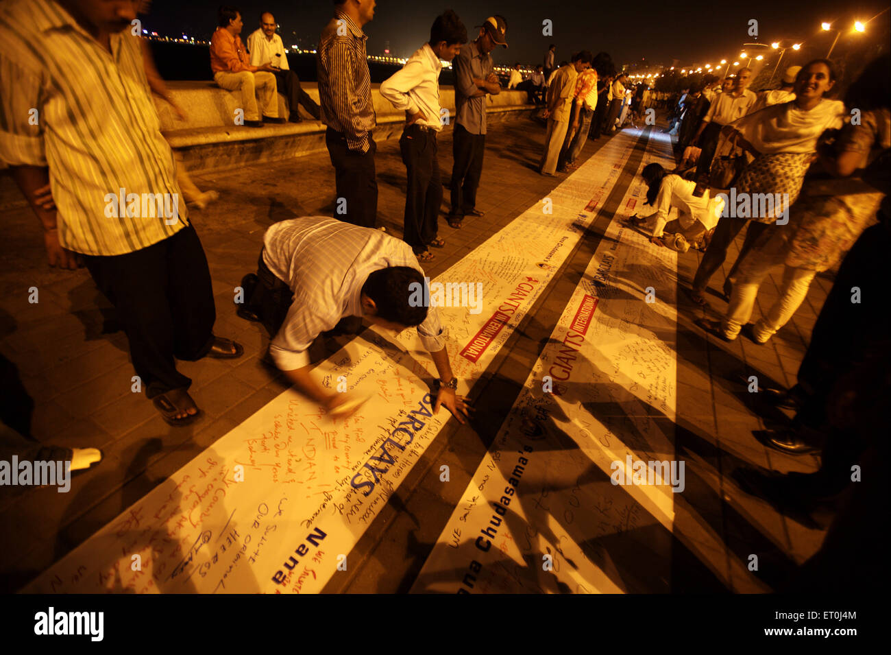 Youths writing message 200 foot banner Trident hotel memory victims killed in terrorist attack 26th November 2008 in Bombay Stock Photo