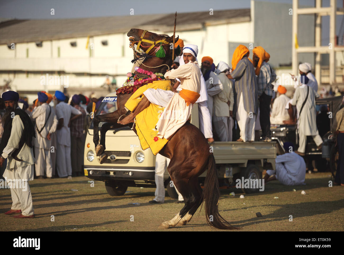 Nihang or Sikh warrior on his horse before stunts perpetual Sikh Guru Granth Sahib at Khalsa Sports ground ; Nanded Stock Photo