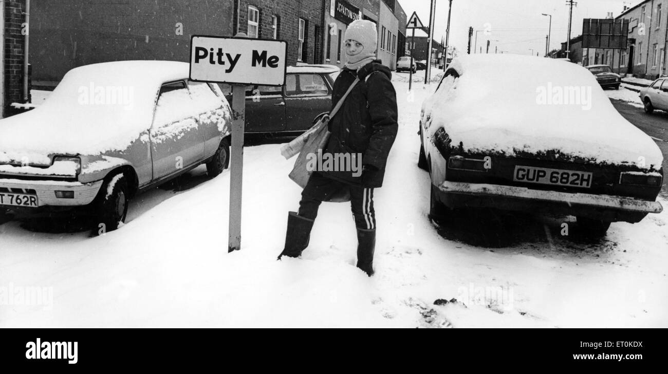 A young boy braves the snow on his paper round in the village of Pity Me in Durham. Circa 1977. Stock Photo
