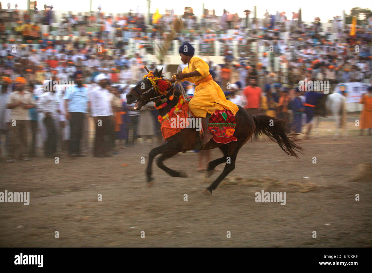 Nihang Sikh warrior performing stunts ; event onsecration of perpetual Guru of Sikh Guru Granth at Khalsa Sports ground Nanded Stock Photo