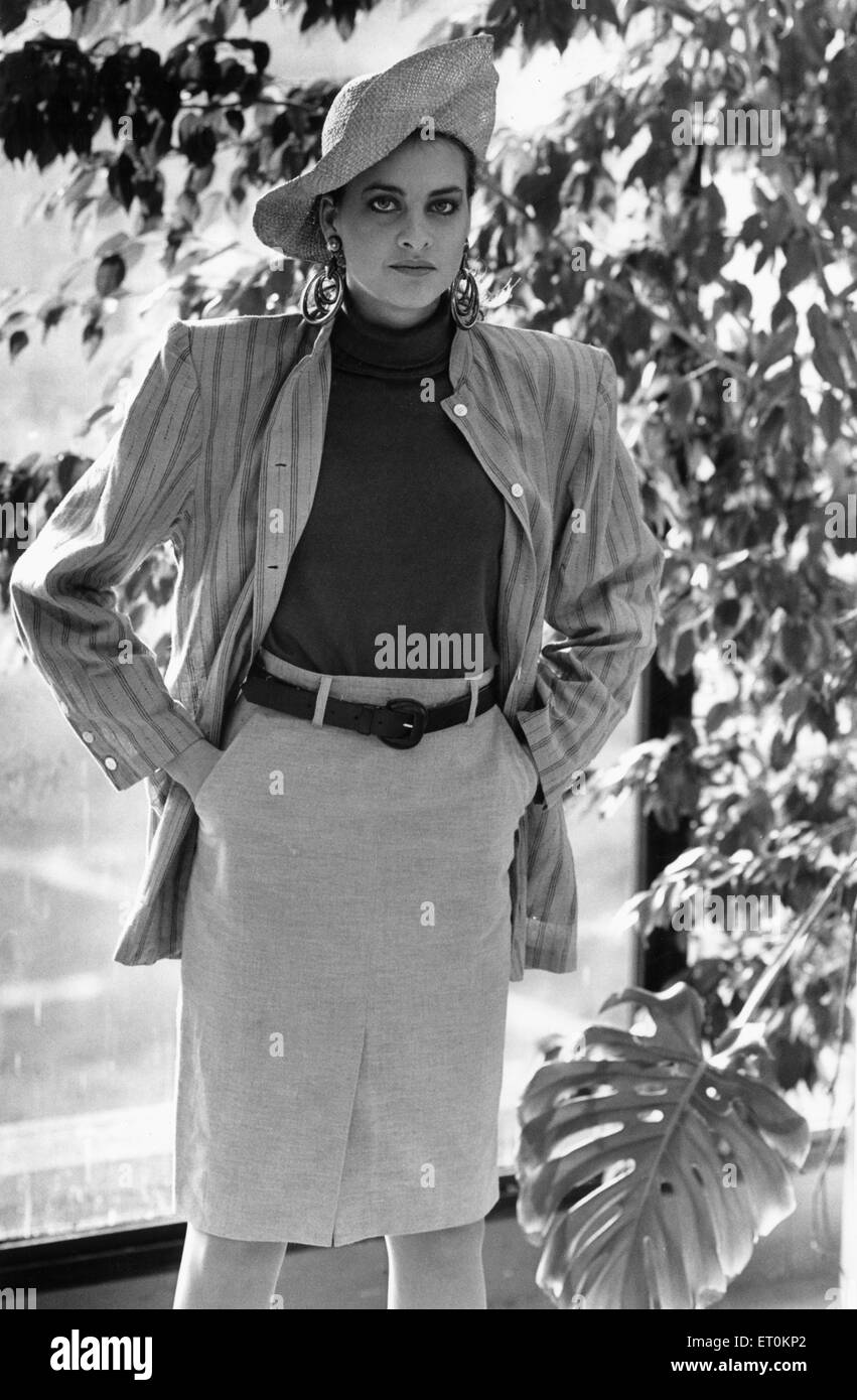 1980s Women's Fashion: Our model wears a waist high belted skirt a stripe jacket over a turtle neck jumper. 23rd February 1987 Stock Photo