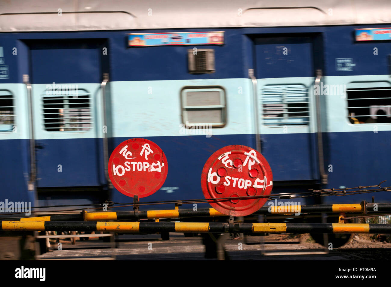 train passing railway level crossing stop sign, Bhopal, Madhya Pradesh, India Stock Photo