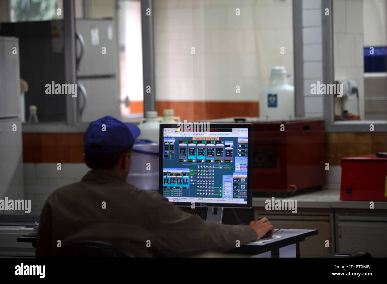 Worker checking standard of milk received at Amul factory in Anand ; Gujarat India Indian quality control Stock Photo