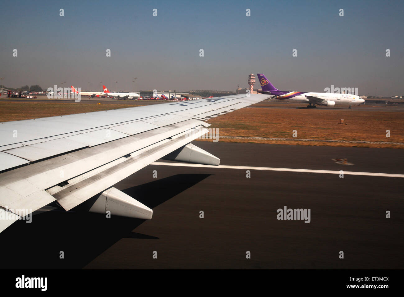 Wing of aircraft whiles aircraft taking off ; India Stock Photo