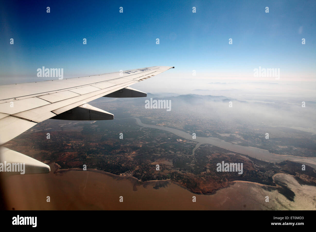 Wing of aircraft flying in sky Stock Photo