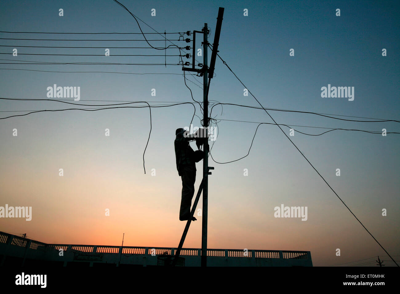 Electricity department personnel working on electric pole in Bhopal ; Madhya Pradesh ; India Stock Photo