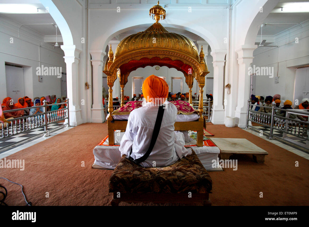 Sikh cleric waves whisk over holy Guru Granth Sahib at the Anandpur Sahib Gurudwara in Rupnagar district ; Punjab ; India Stock Photo