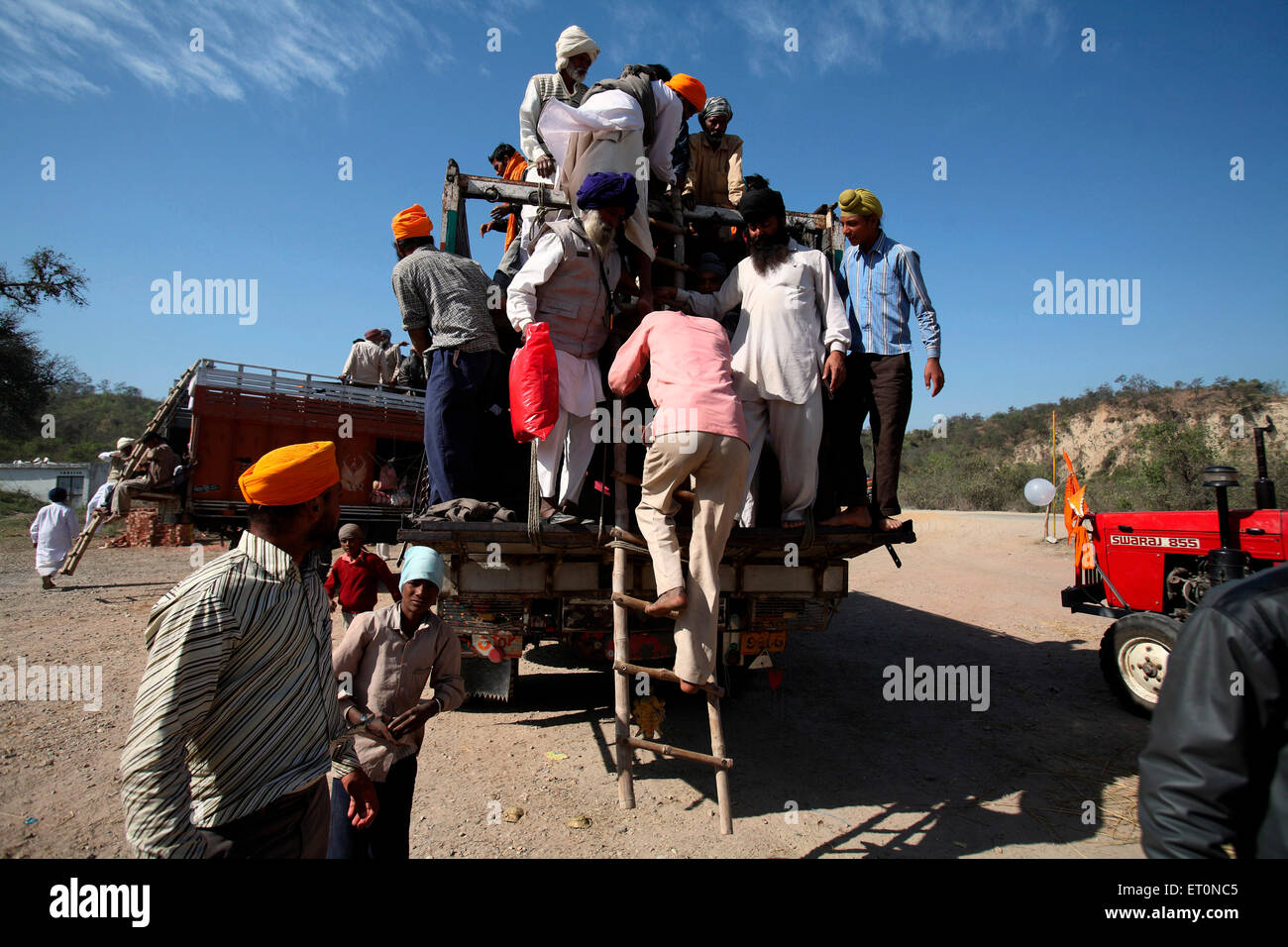 People getting down from truck in Punjab ; India Stock Photo