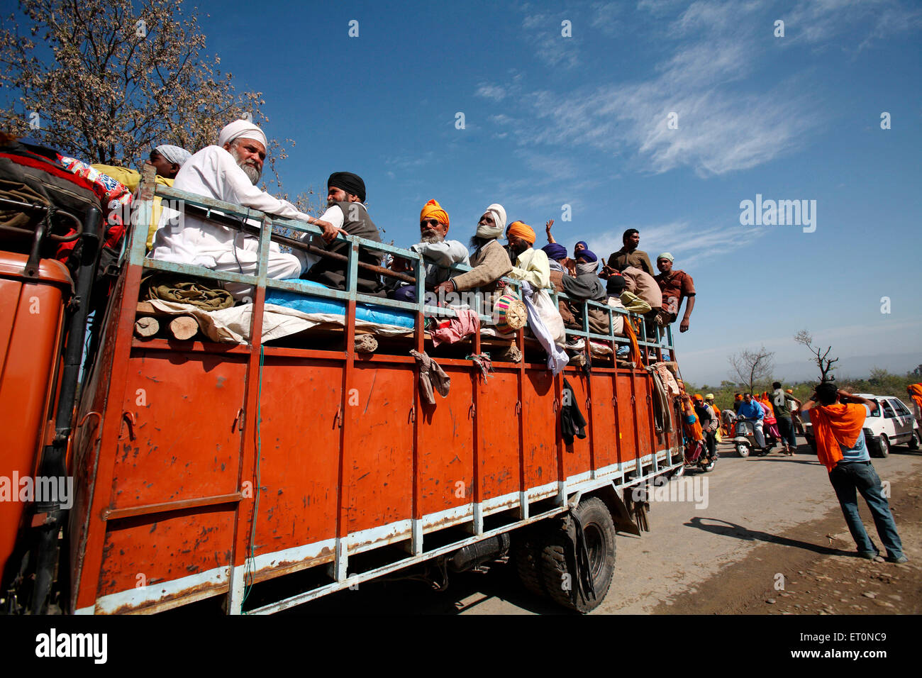 People travelling sitting on truck in Punjab ; India Stock Photo