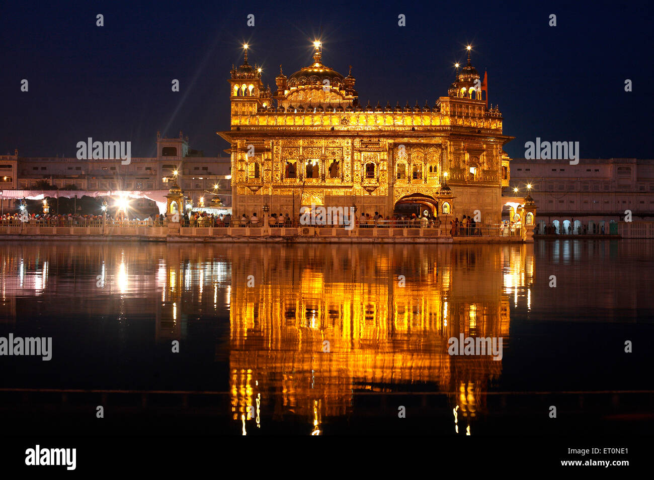 Glow of Harmandir Sahib or Darbar Sahib or Golden temple reflection in lake in Amritsar; Punjab ; India Stock Photo
