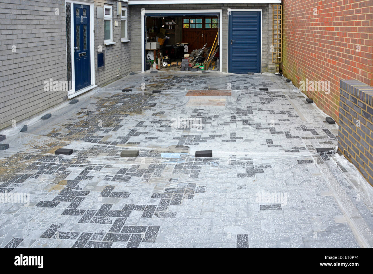 Plastic sheeting laid over new concrete block paving to stop storm