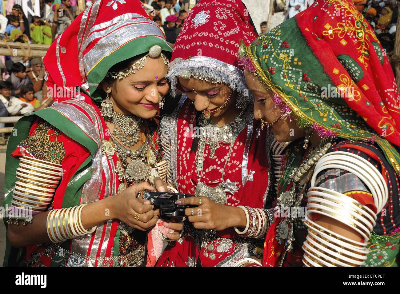 Girls in traditional jewellery and rajasthani costume looking at camera ; Pushkar fair ; Rajasthan ; India NO MR Stock Photo