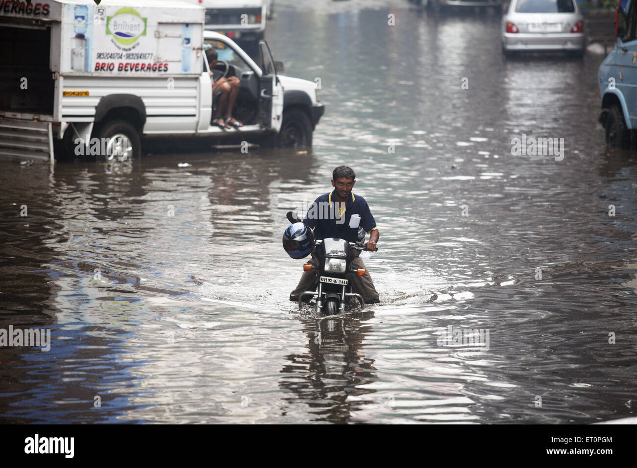 Man trying to drive through the water in powai ; Bombay ; Mumbai ; Maharashtra ; India NOMR Stock Photo