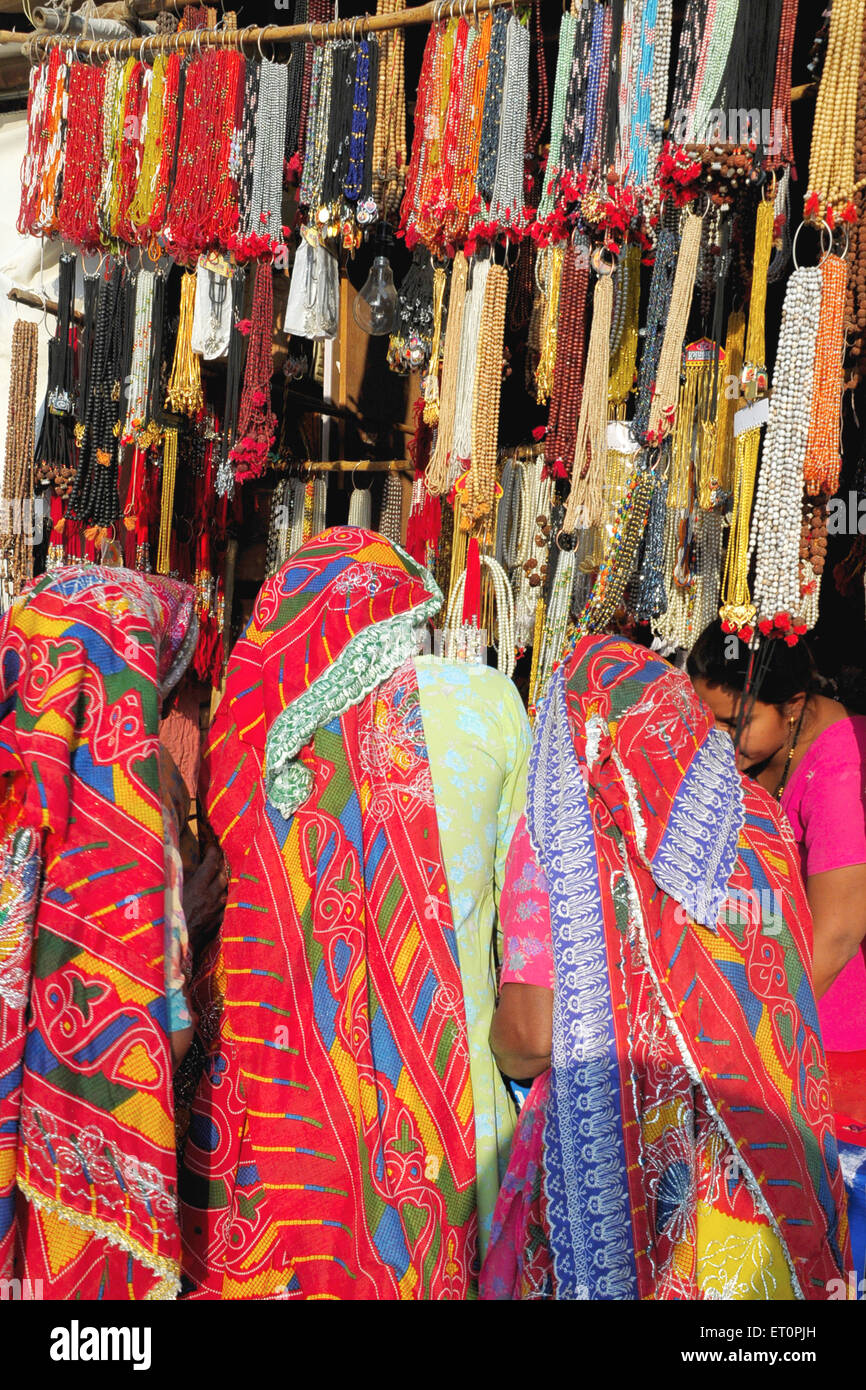 Rajasthani ladies shopping at shop in Pushkar fair ; Rajasthan ; India