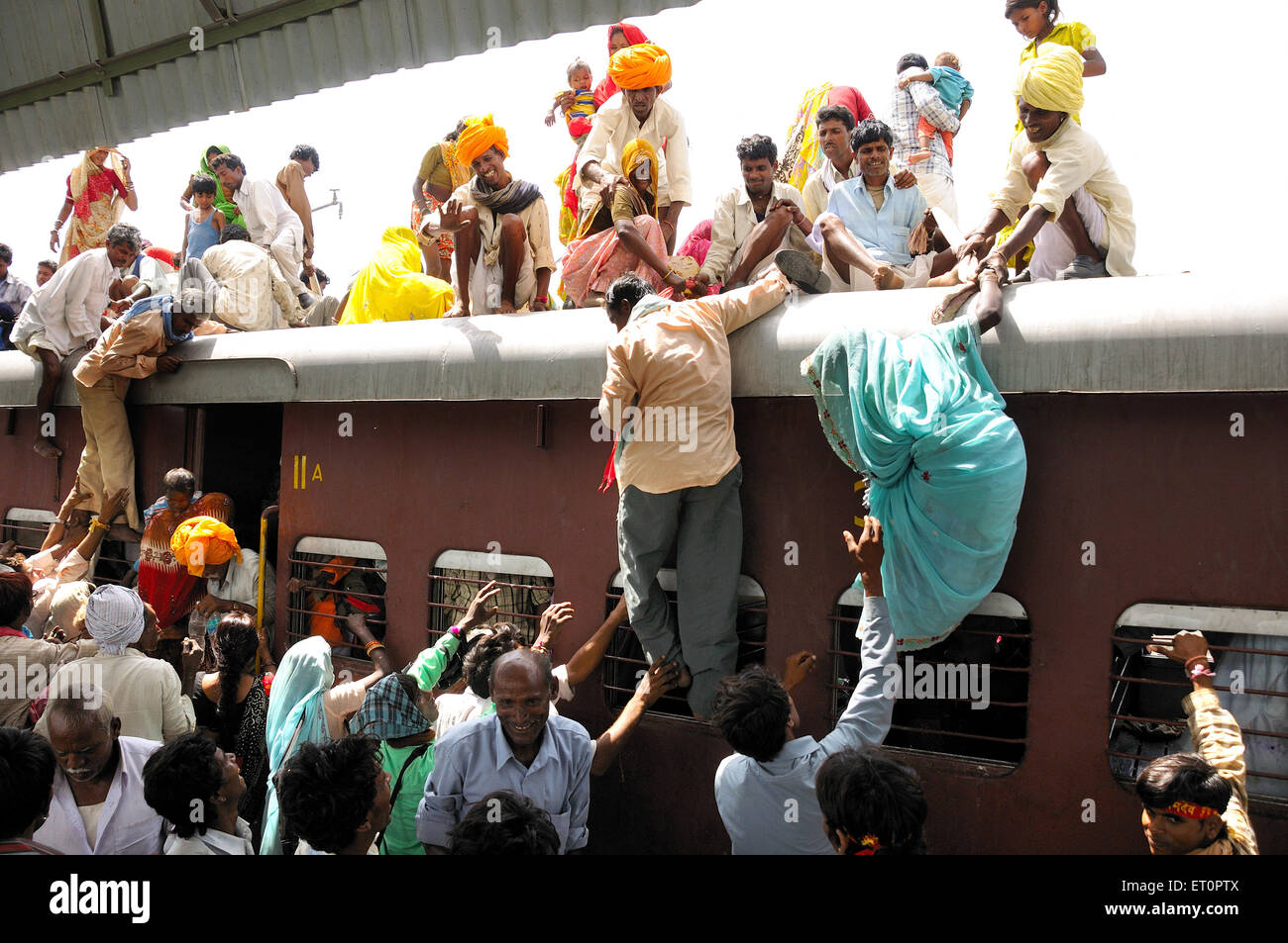 People climbing on roof of train for risky travel ; Marwar railway station ; Rajasthan ; India Stock Photo