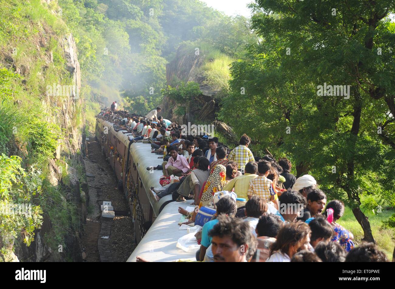 People taking risk while travelling on roof of train ; Goram ghat ; Marwar Junction ; Rajasthan ; India Stock Photo