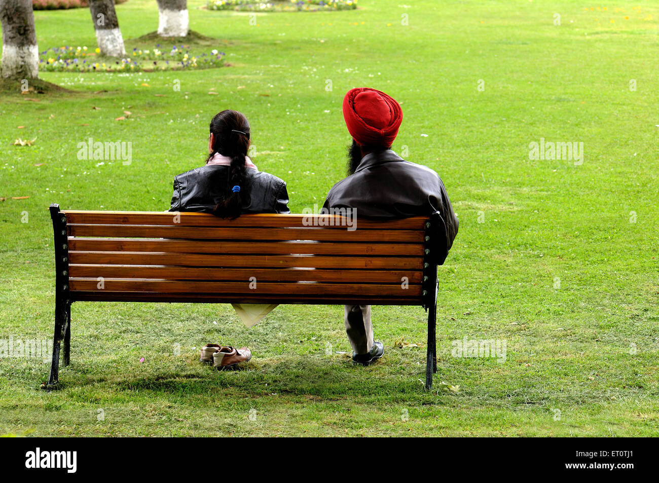 Couple sitting on bench in garden ; India Stock Photo