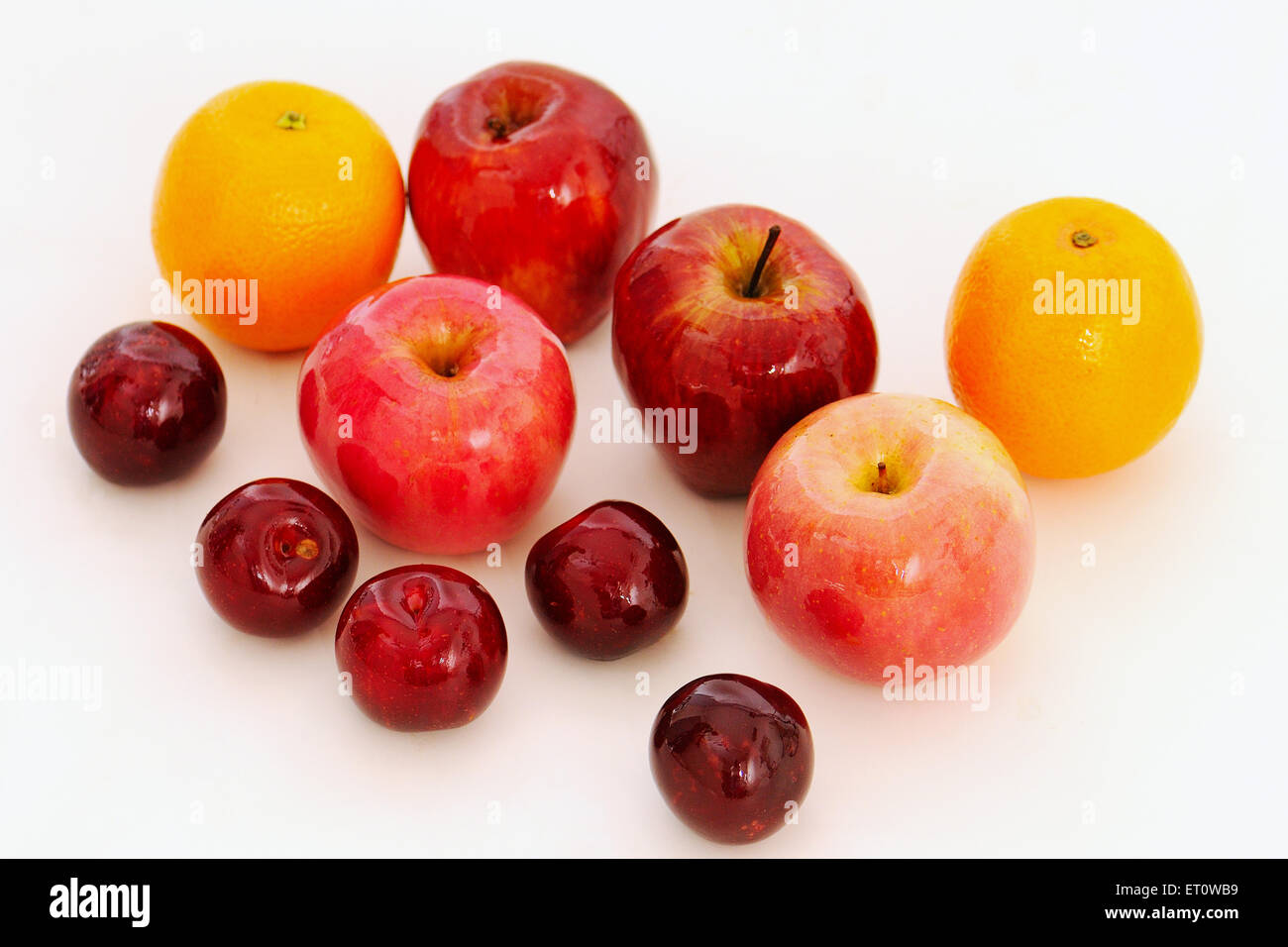 apples oranges plums on white background Stock Photo